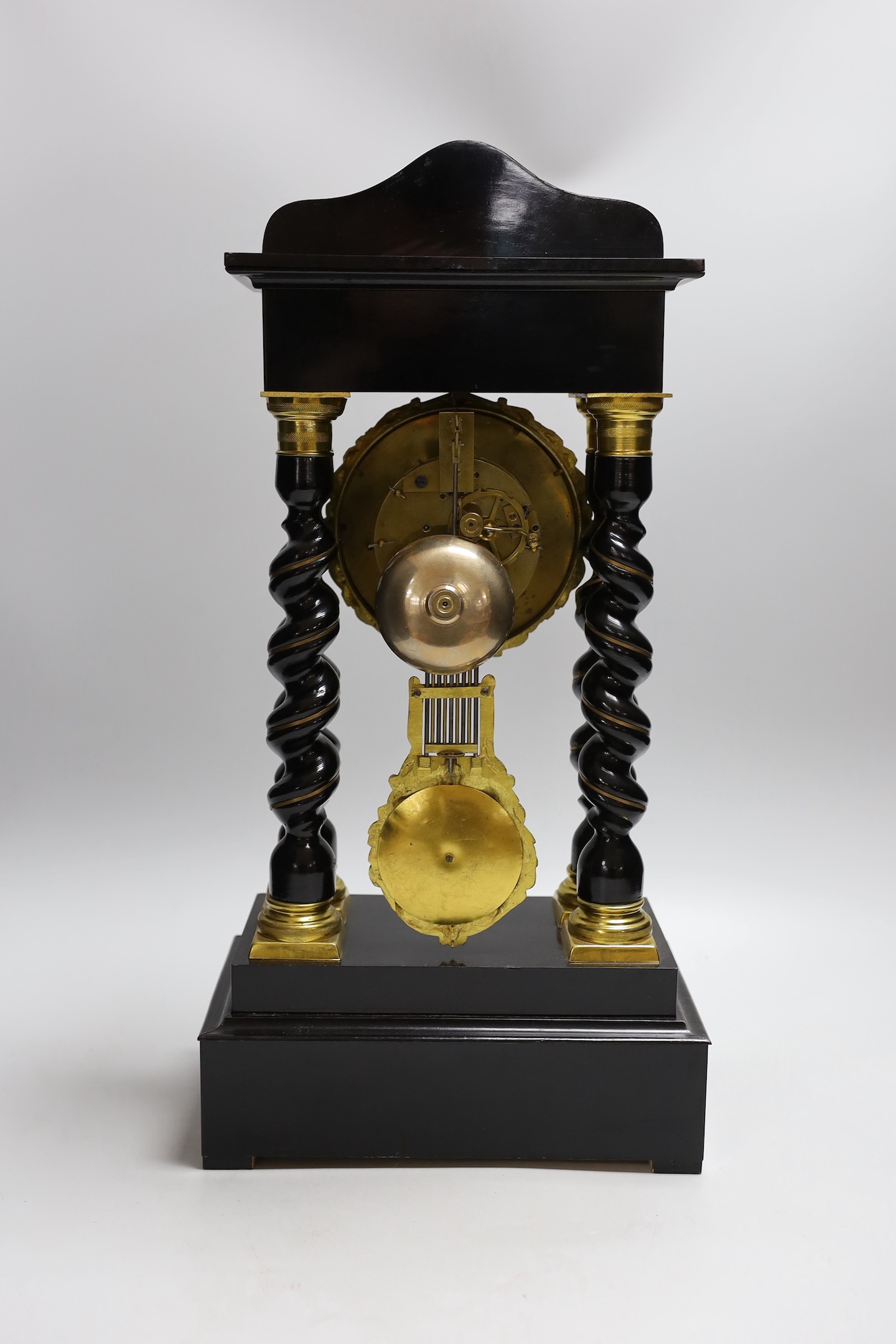 A French Napoleon III ebonised and brass inlaid portico clock. 49cm tall